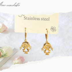 Aretes chicos huggies dorados acero inoxidable con dijes de niñas. Los aretes huggies son un tipo de aretes pequeños que se ajustan muy cerca del lóbulo de la oreja, creando un efecto de "abrazo". A diferencia de los aros tradicionales, los huggies son más delicados y se ajustan de manera más ceñida, lo que los hace muy cómodos para usar durante largos periodos de tiempo. 
