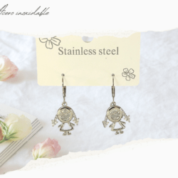 Aretes chicos huggies plateados acero inoxidable con dijes de niñas. Los aretes huggies son un tipo de aretes pequeños que se ajustan muy cerca del lóbulo de la oreja, creando un efecto de "abrazo". A diferencia de los aros tradicionales, los huggies son más delicados y se ajustan de manera más ceñida, lo que los hace muy cómodos para usar durante largos periodos de tiempo. 